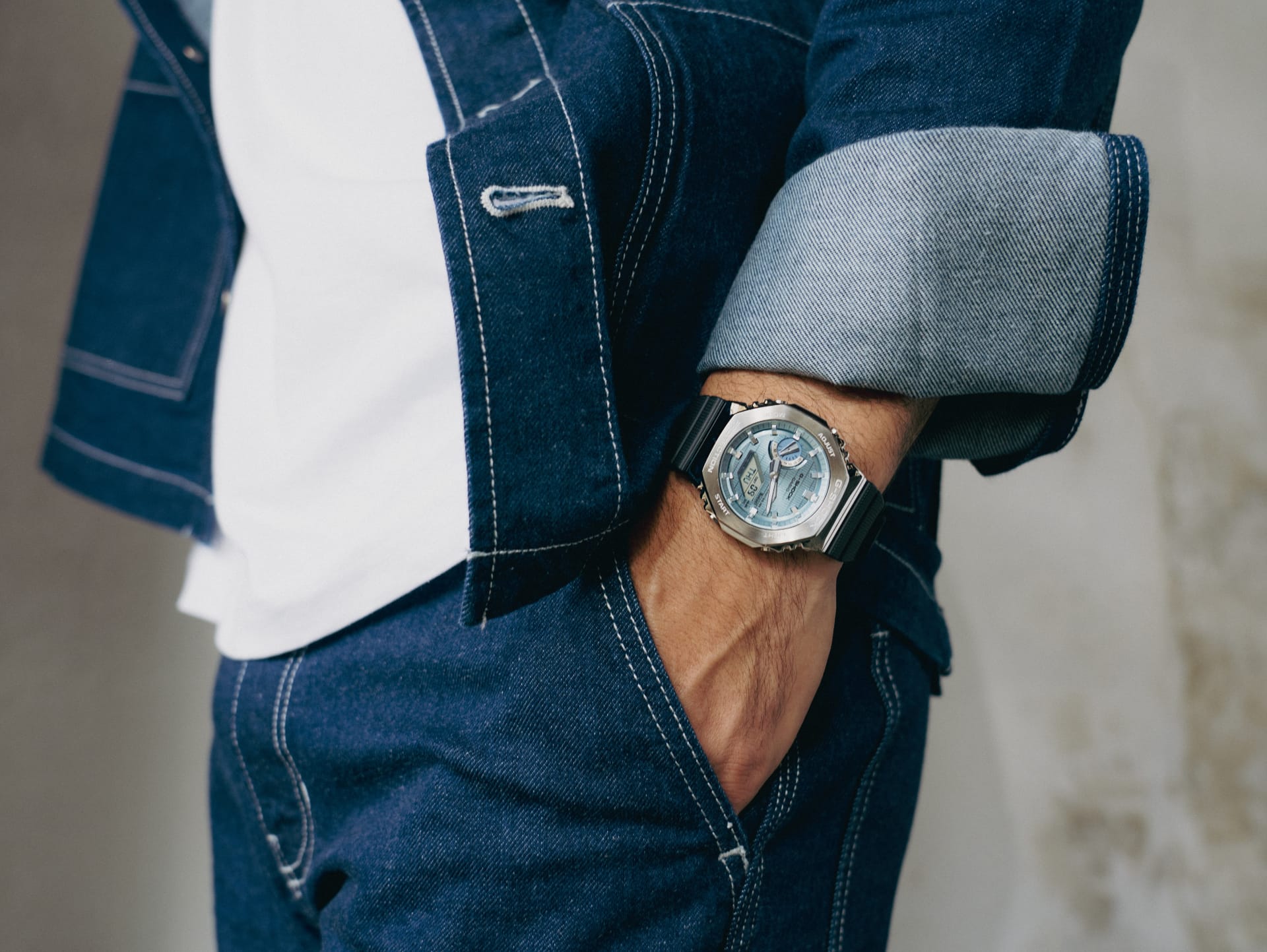 Ein junger Mannim Denim Look trägt die G-Shock GBM-2100 mit hellblauem Zifferblatt.