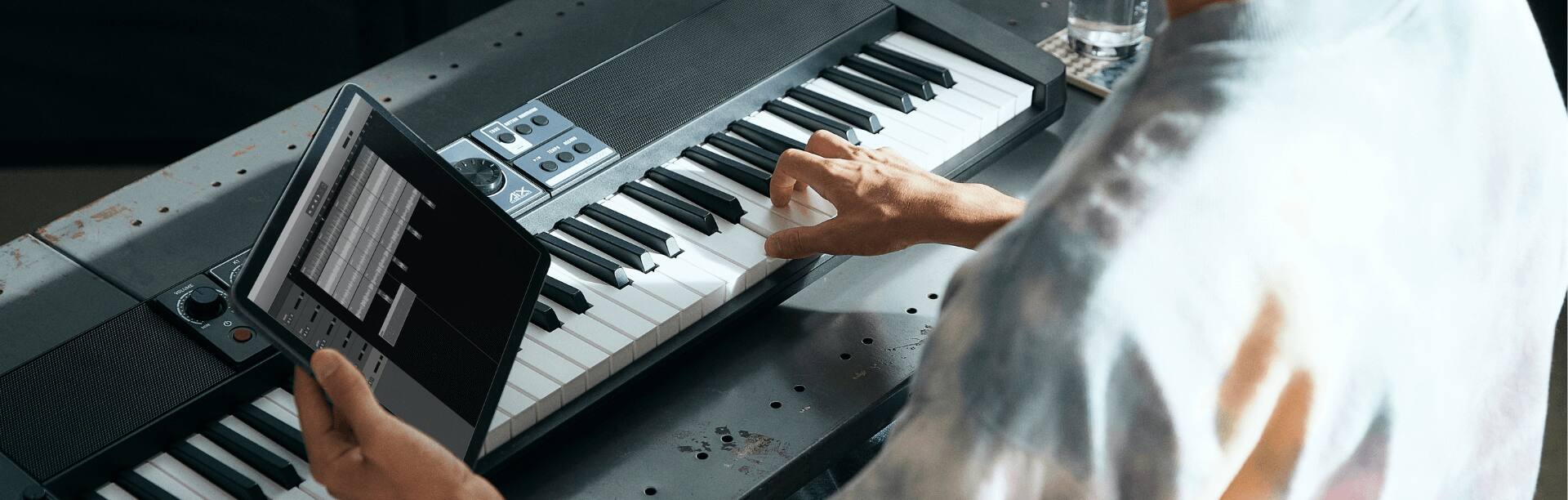 Das CT-S500 Keyboard wird gespielt und nebenbei auf ein iPad geschaut. Das Bild verlinkt zur Casiotone-Technologie-Seite.