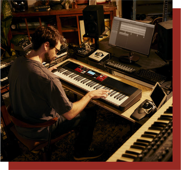 Ein Mann spielt an einem CTV1000V Keyboard in einem Raum voller Musik-Equipment