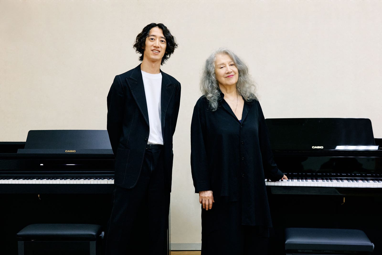 Martha Argerich und Hayato Sumino stehen in schwarzer Kleider vor Celviano Pianos.