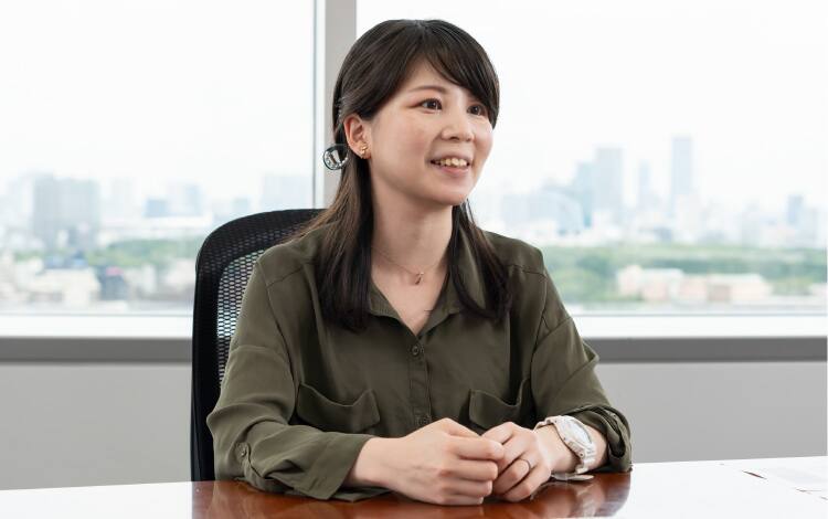Miki Suzuki, Hardware Strategy Abteilung, sitzt in brauner Bluse vor ihrem Schreibtisch