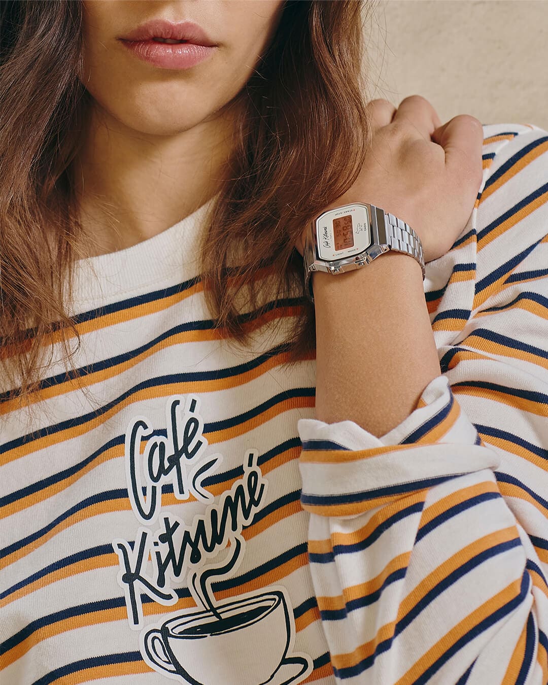 Ein Modell trägt Kollaborationsuhr von Casio Vintage und Café Kitsuné. Auf ihrem Pullover ist das Logo von Café Kitsuné zu sehen.