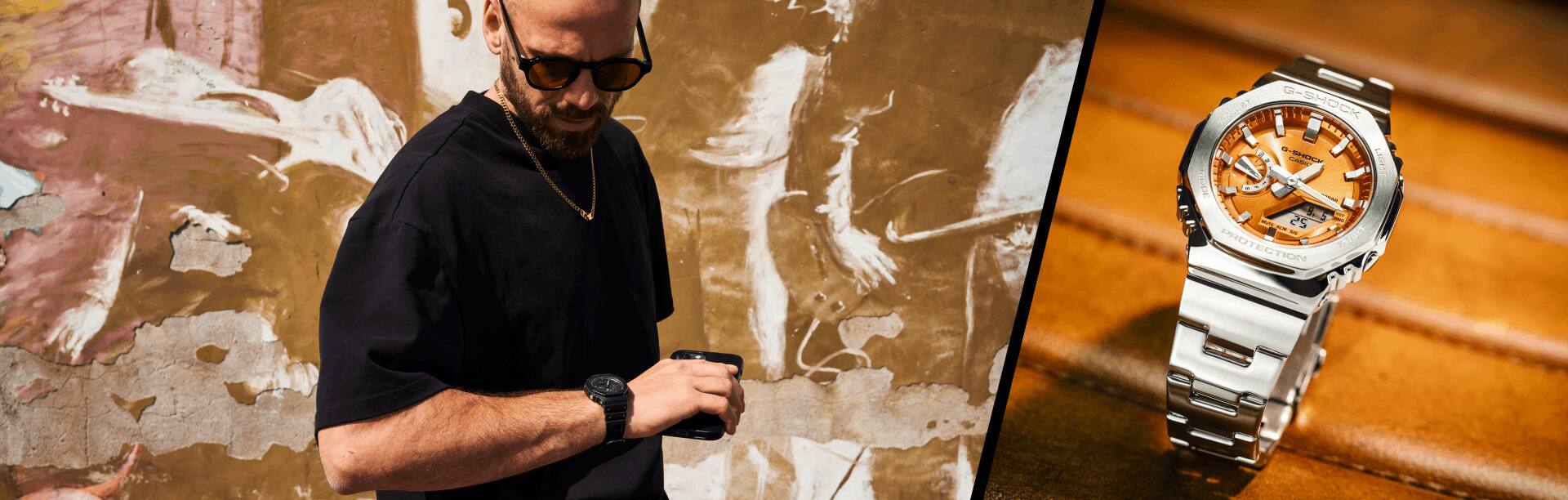 Auf der linken Seite ist ein Mann in schwarzem Shirt mit der schwarzen GA-2100 Armbanduhr von G-SHOCK zu sehen, rechts daneben ist die silber-orangene Metalluhr GM-2100 auf einem Lederstuhl zu sehen.