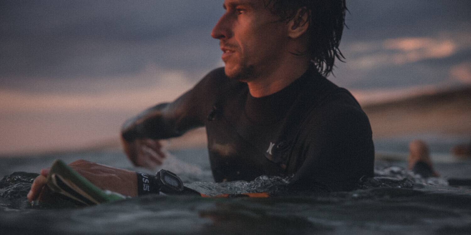 Ein Surfer im Wasser mit G-Shock G-Lide Uhr 