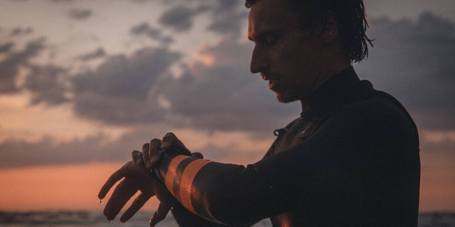 Ein Surfer guckt auf seine G-Shock G-Lide 