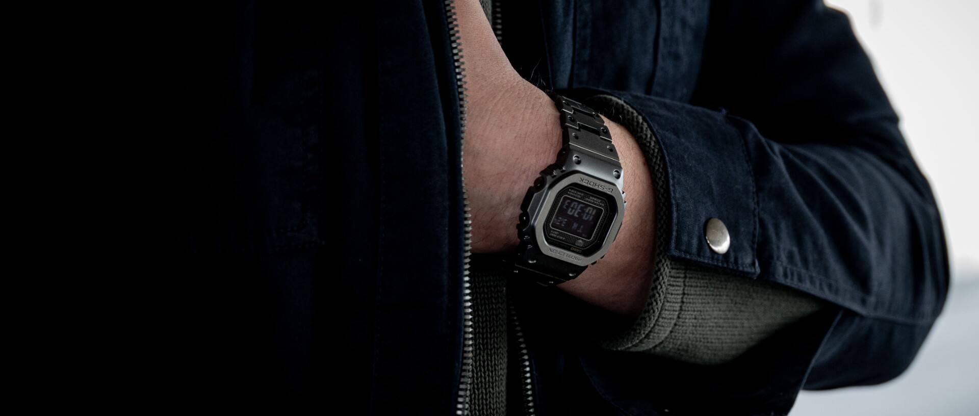 Die Casio G-Shock GMW-B5000A am Handgelenk einer Person in schwarzer Kleidung