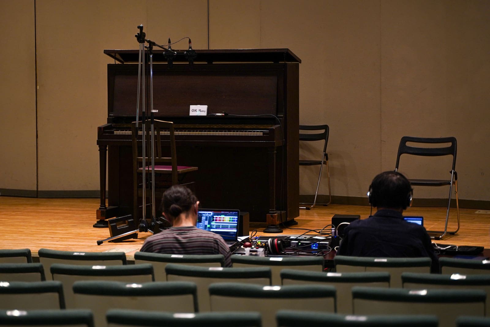 A photo of people attempting to record the sound of a piano