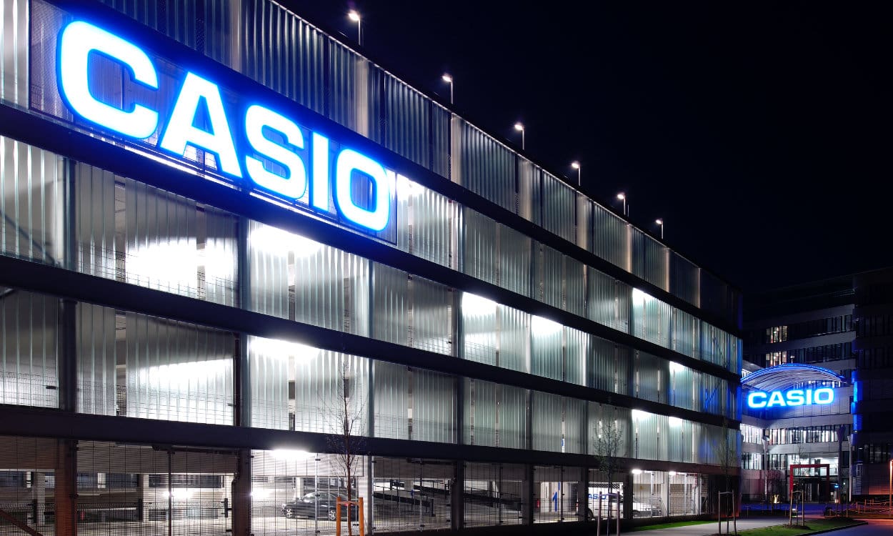 Das CASIO Office in Norderstedt bei Nacht mit dem blau-beleuchtetem Schriftzug am Haupteingang und am Parkhaus