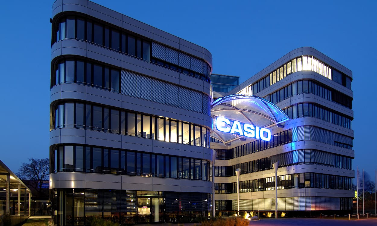Das Bürogebäude von CASIO in Norderstedt mit 6 Stockwerken in der Dämmerung mit beleuchtetem Schriftzug am Haupteingang