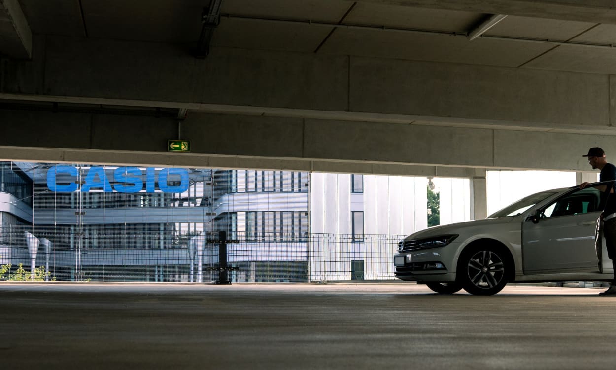 Casio Team beim AOK Firmenlauf Event in weißen Casio T Shirts vor Veranstaltungsbanner auf einer Wiese