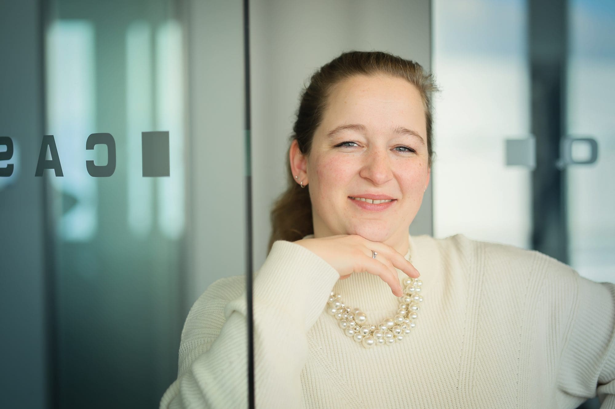 Eine Frau am Tablet steht vor einem Serverraum