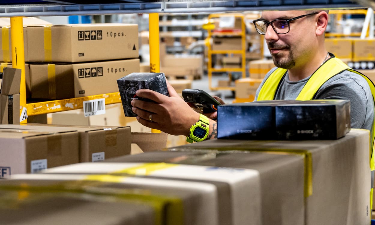 Ein Mitarbeiter scannt in der Logistik Pakete