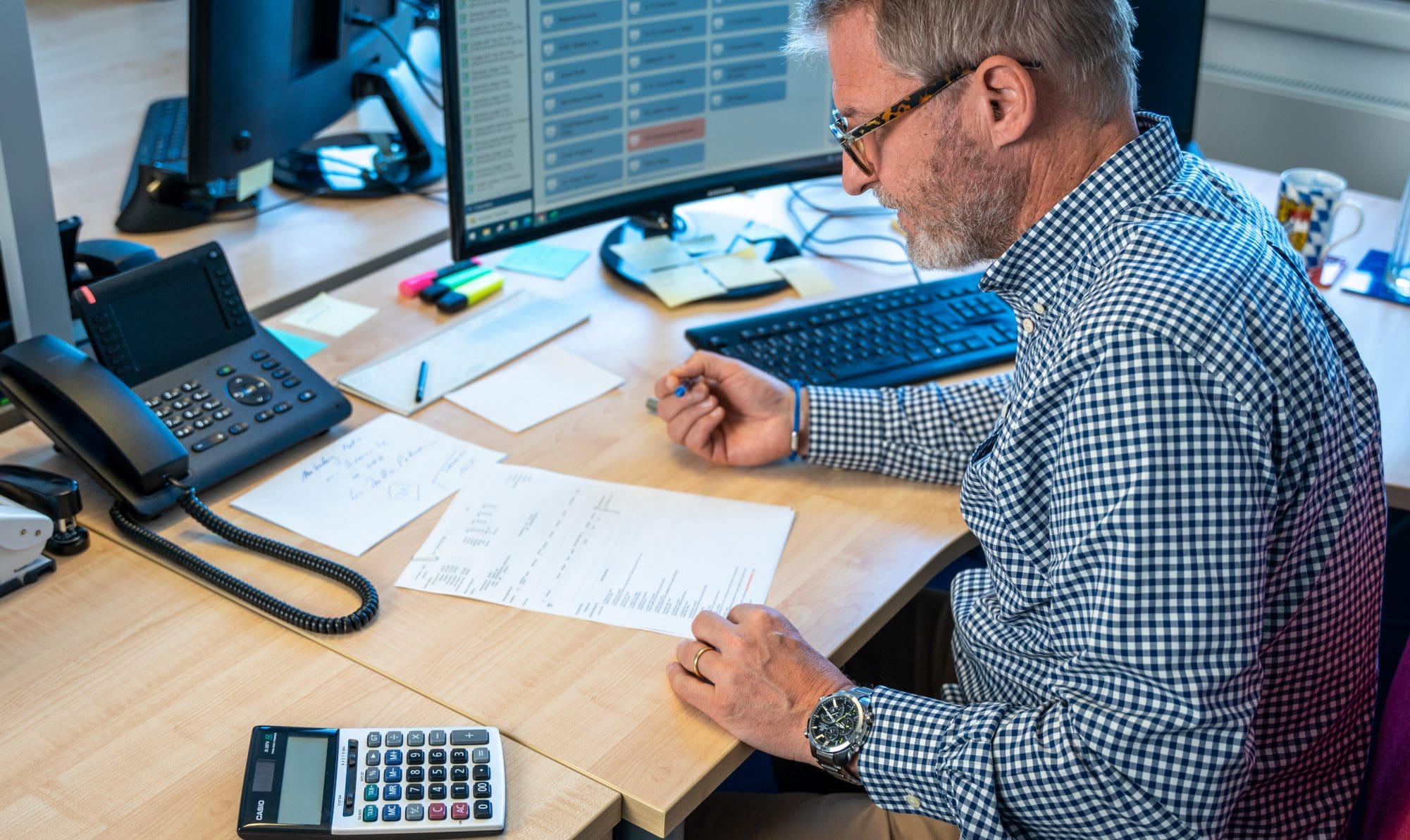 Eine Mitarbeiterin aus der IT-Abteilung steht mit einem Tablet am Server