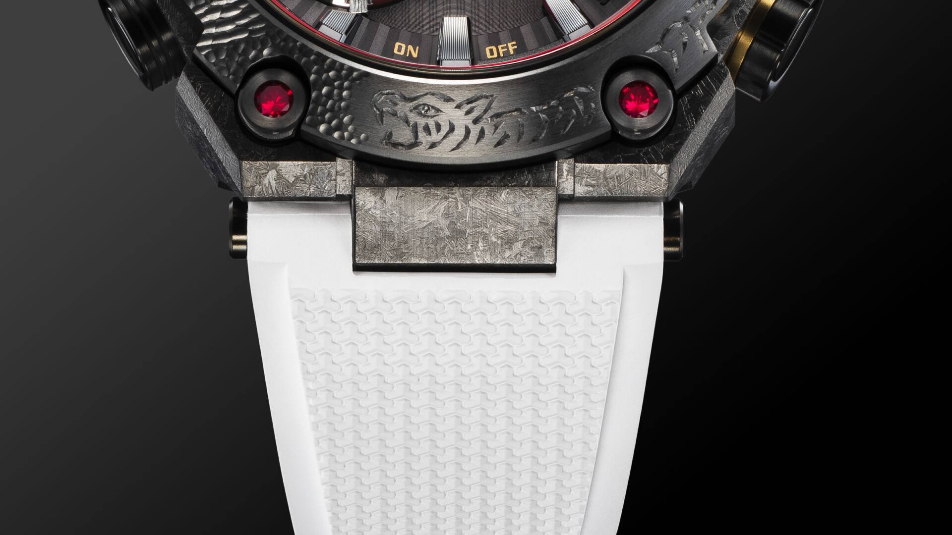 Nahaufnahme des Übergangs vom reinweißen Armband zum aufwendig gravierten Metallgehäuse