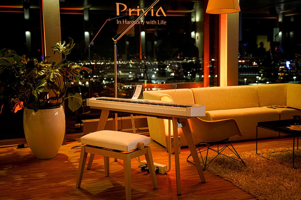 Ein Showroom mit Sofa, Pflanzen und dem Privia Piano von CASIO