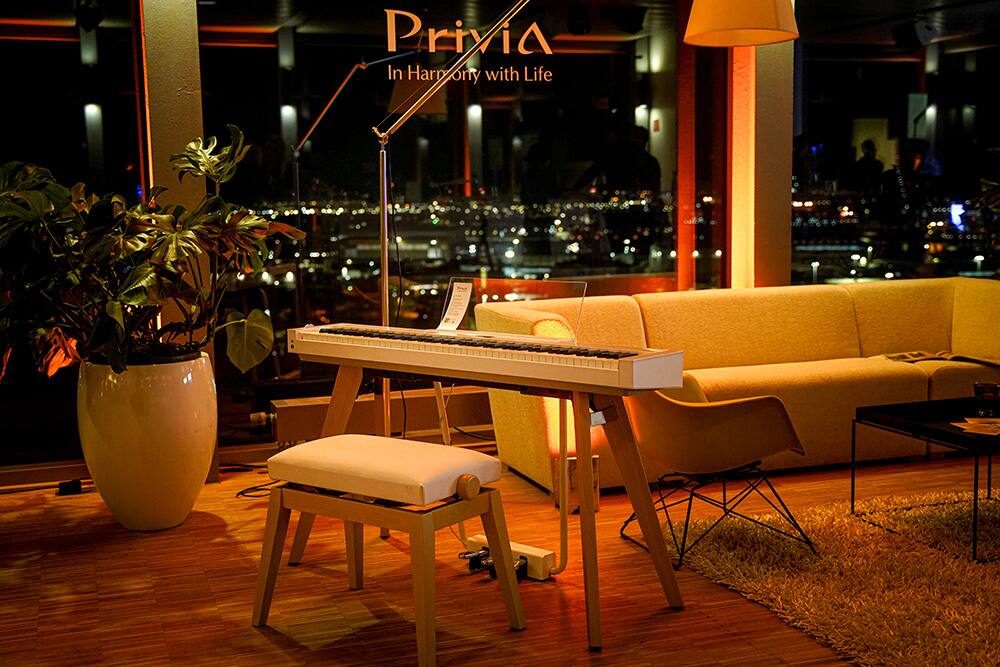 Ein Showroom mit Sofa, Pflanzen und dem Privia Piano von Casio