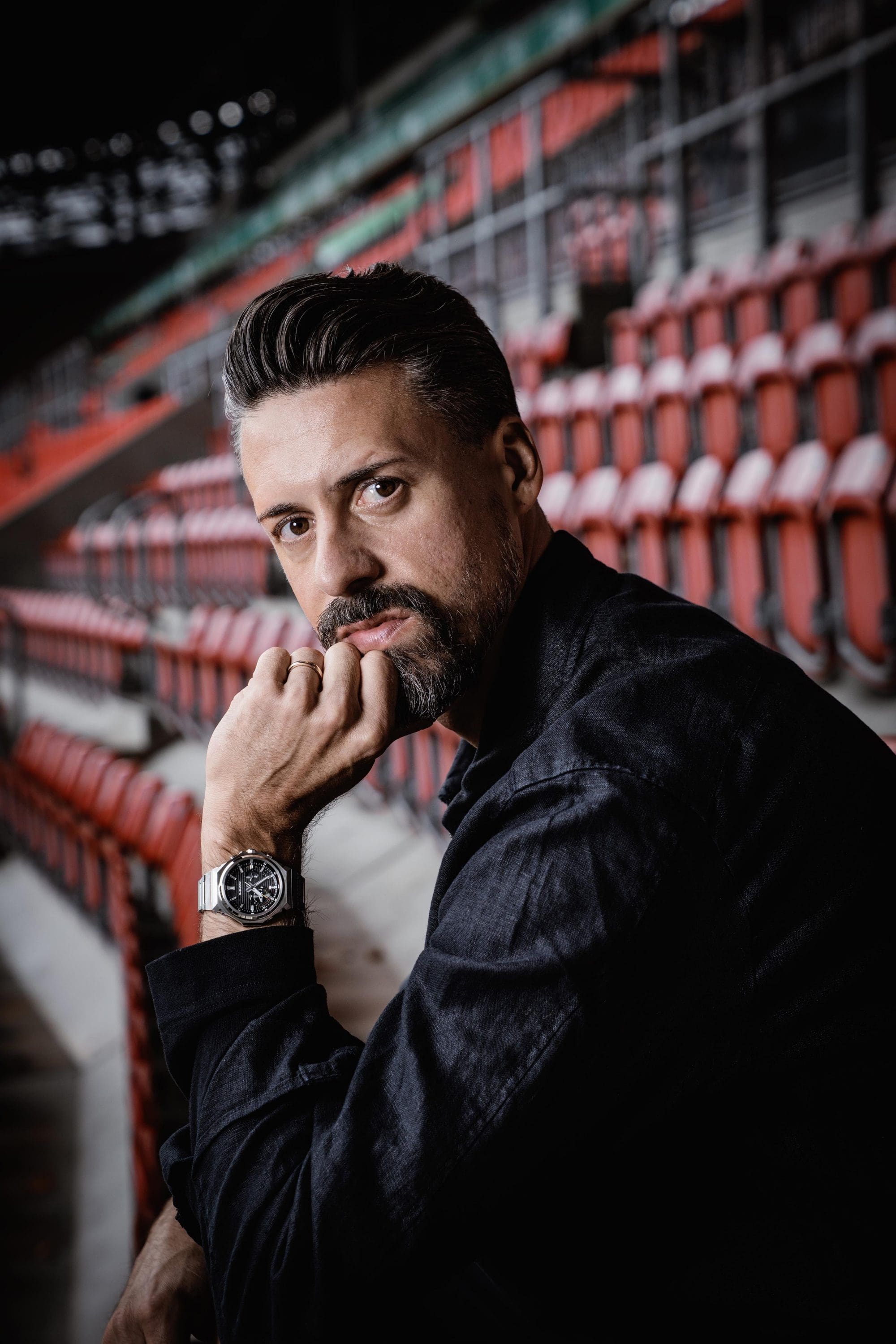 Sandro Wagner sitzt im leeren Stadion und trägt die GST-B1000.