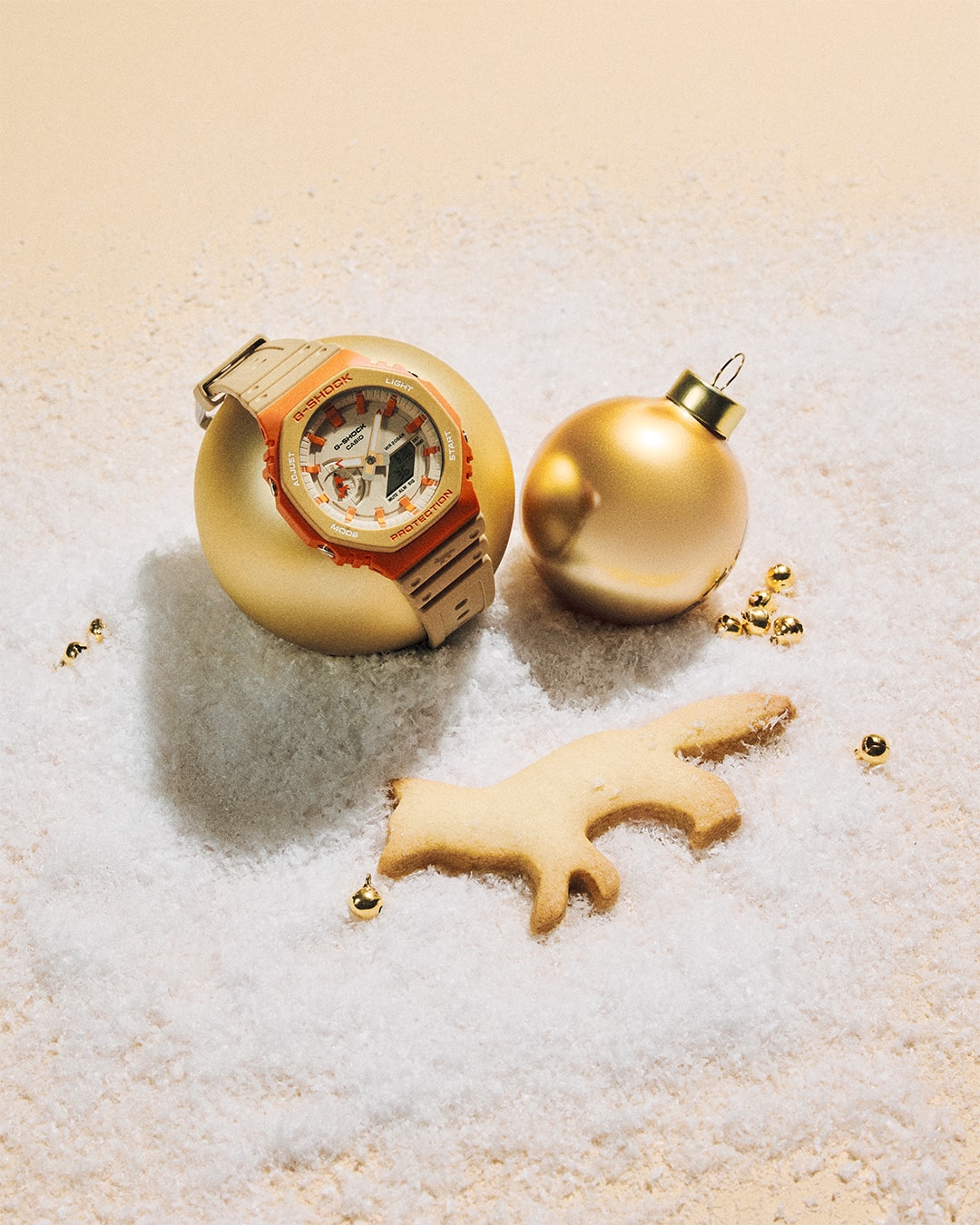 Die G-SHOCK GA-2110MK-5AER mit goldener Weihnachtsdeko auf weißem Untergrund.