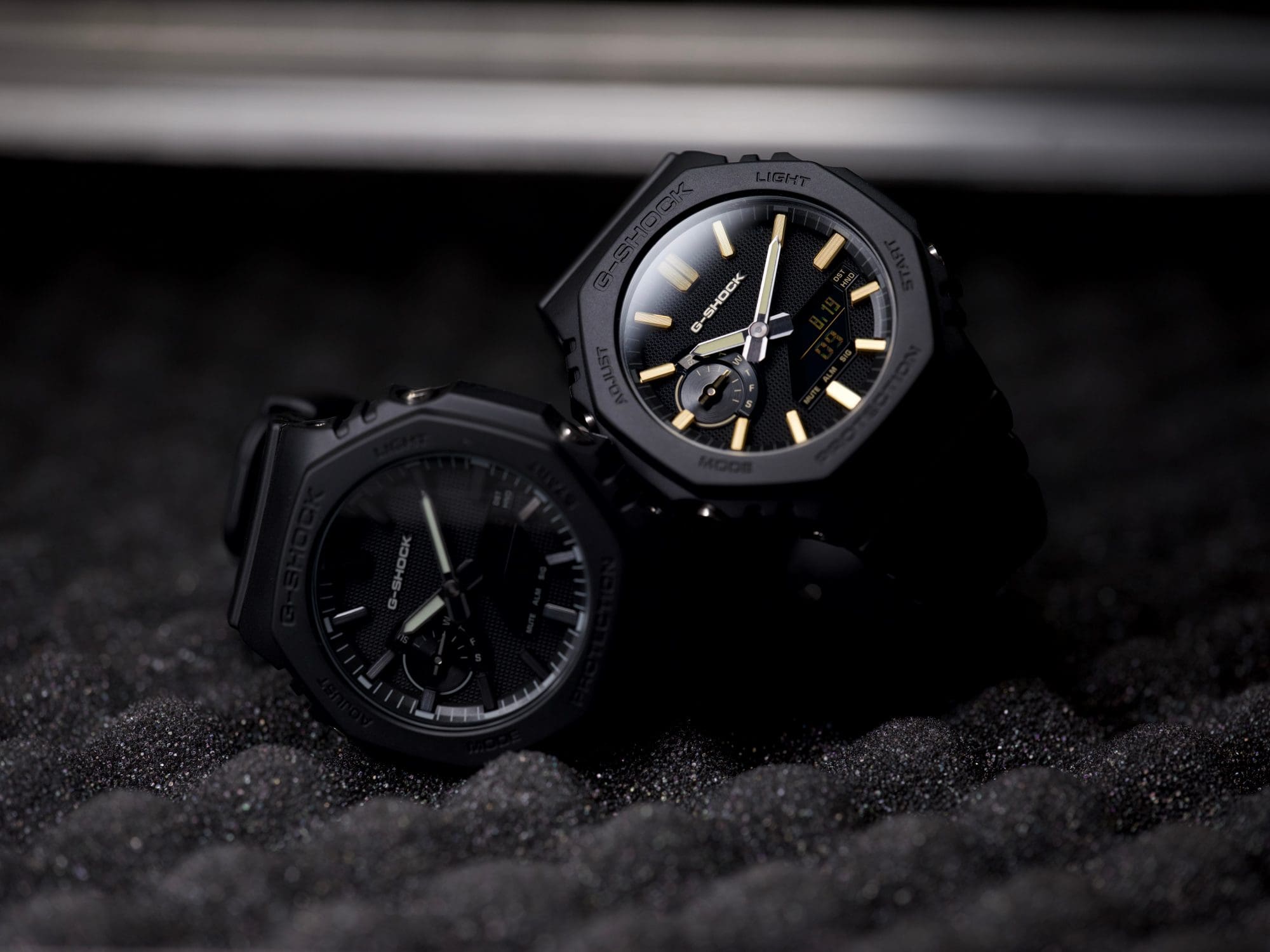 Zwei GA-2100LXB Uhrenmodelle mit schwarzen Armbändern aus Resin