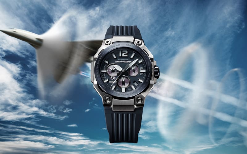 Der schwarze GWR-B3000-1A Chronograph mit silbernem Metallgehäuse vor einem blauen Himmel mit startendem Überschallflugzeug
