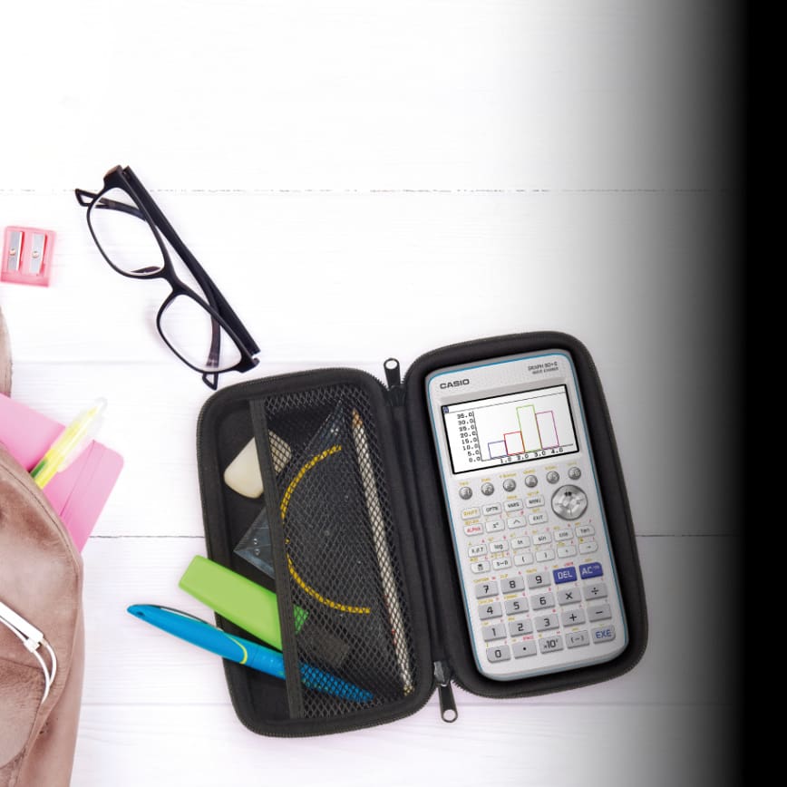 Hipster grey leather backpack, full of school supplies, blank screen cell phone, earphones, pink & yellow notebook, glasses, mini alarm clock. Back to school concept. Close up, copy space, flat lay. Der Taschenrechner Graph90+E mit Case auf einem Schreibtisch