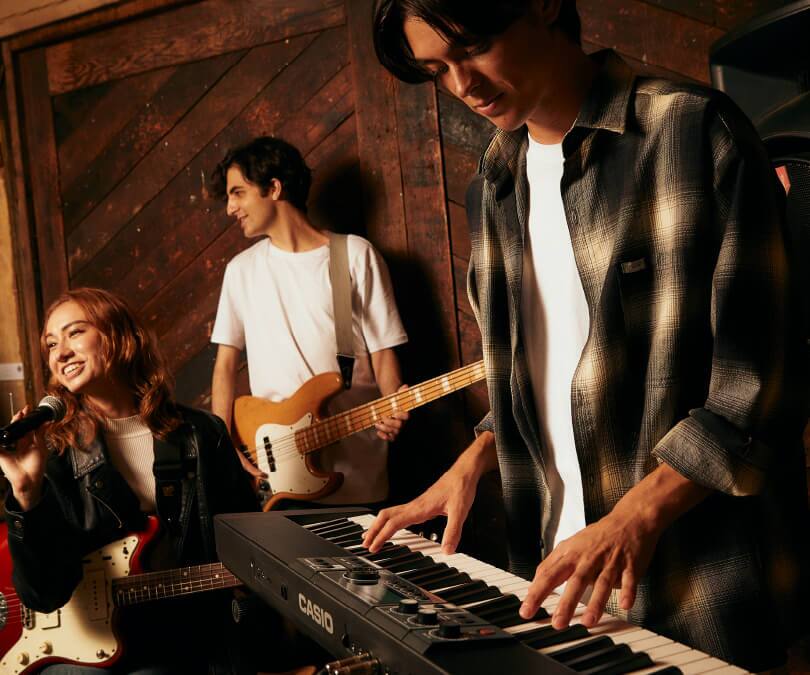 Ein Keyboarder spielt auf dem Casiotone CT-S500 Digitalpiano zusammen mit einer Sängerin und einem Gitarrenspieler