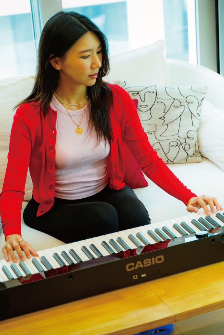 Die koreanische Markenvermarkterin Jisoo Won spielt in ihrer Wohung in Seoul auf ihrem schwarzen Privia Digitalpiano.  Das Bild verlinkt zu ihrer Life with Privia-Seite.