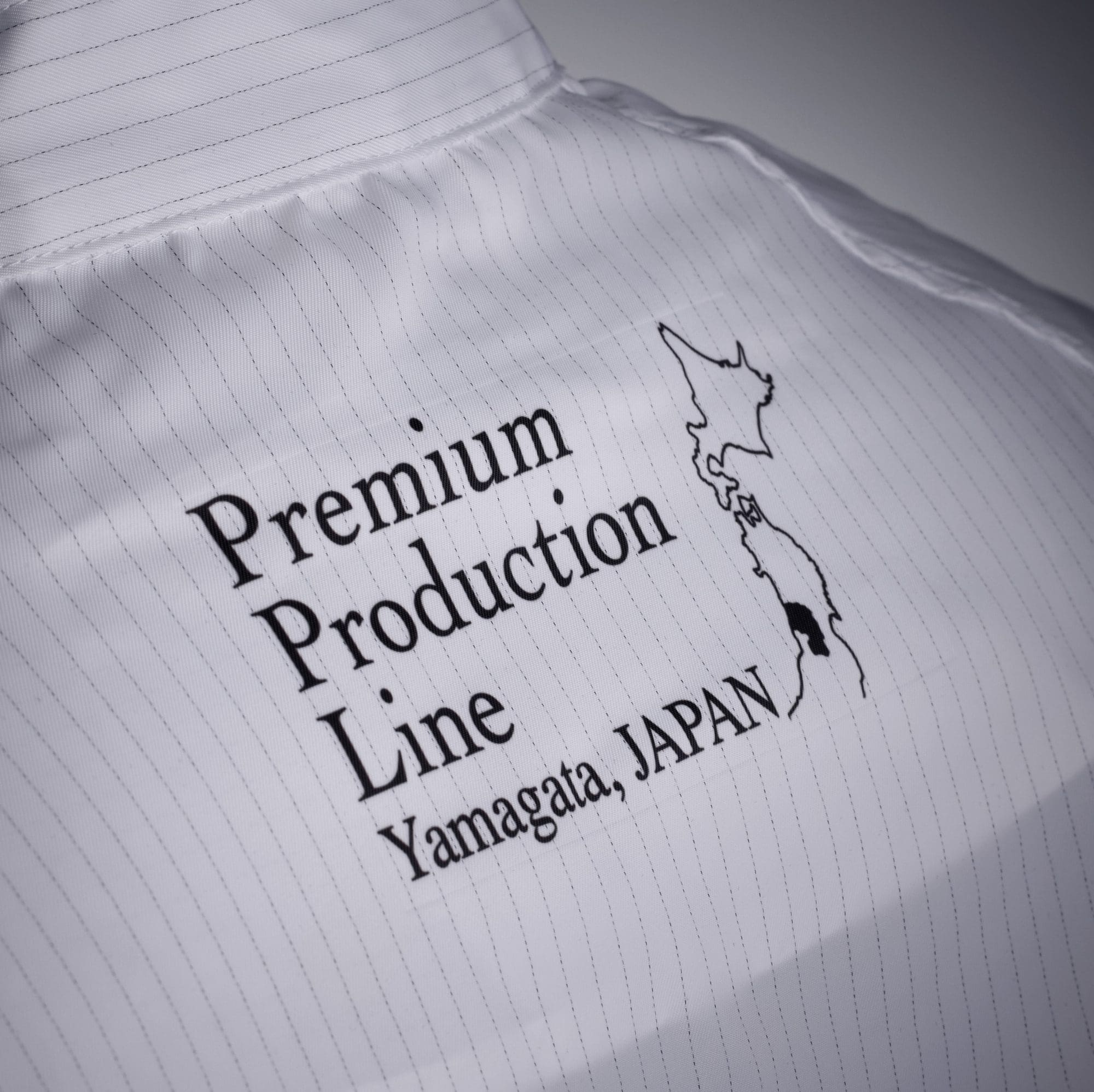Rückansicht eines Kittels mit der Auffrischt "Premium Production Line Yamagata, Japan"