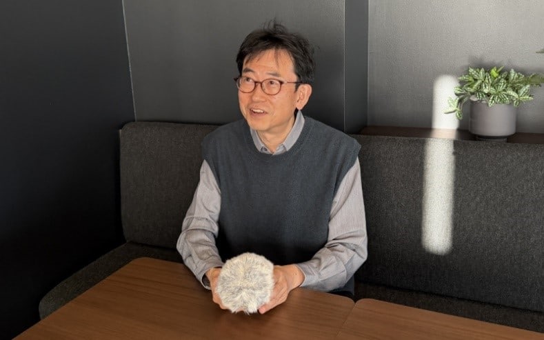 Wataru Nimura mit einem Moflin in der Hand im Interview