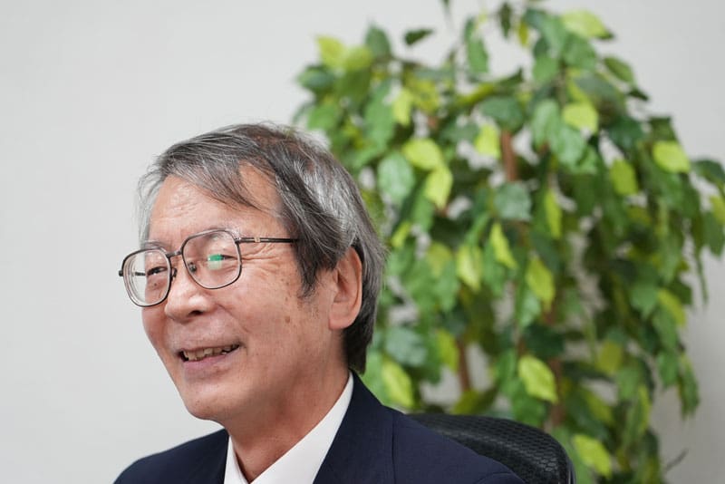 Porträt des lächelnden Entwicklers Yoshino mit seiner Brille