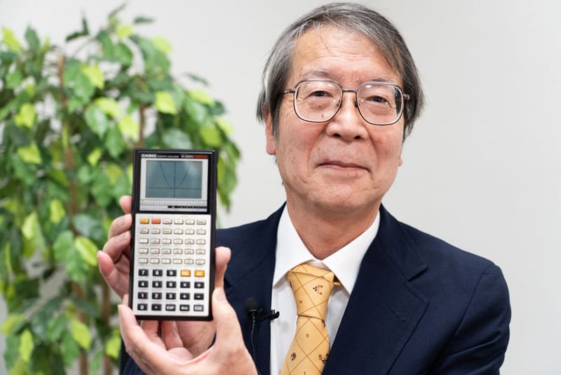 Der Entwickler Hiroyuki Yoshino hält denGrafikrechner fx-7000G von CASIO in den Händen