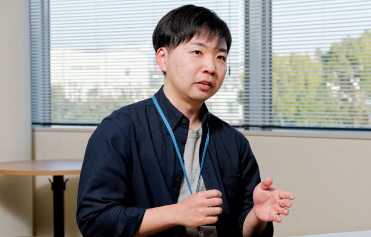 Bild des Ingenieurs Naoki Sekiya mit schwarzen Haaren und dunkelblauem Hemd