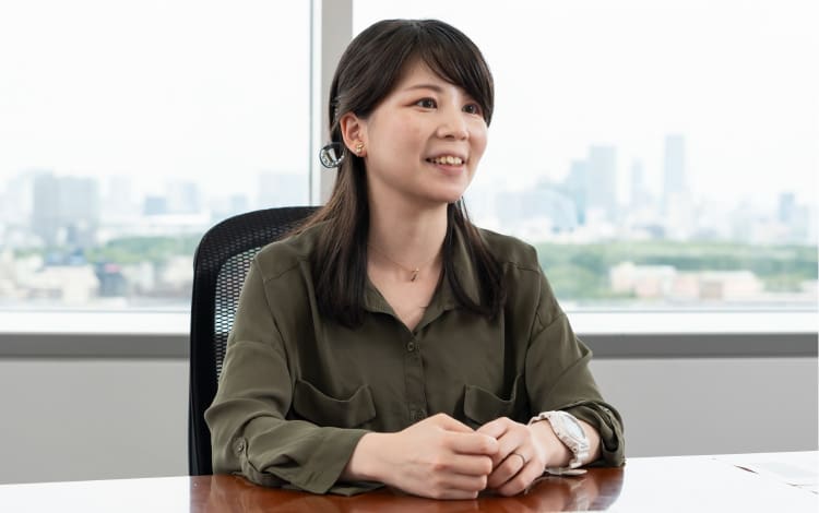Miki Suzuki, Hardware Strategy Abteilung, sitzt in brauner Bluse vor ihrem Schreibtisch