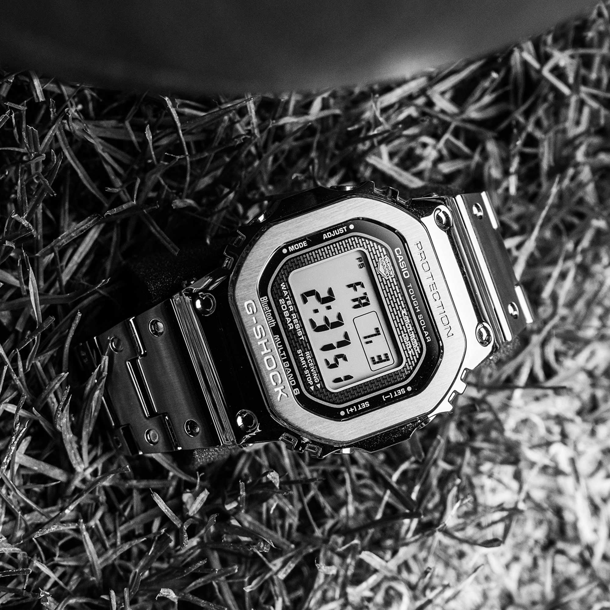 Schwarz-weiß Aufnahme der GMW-B5000D, die auf Grashalmen liegt. 