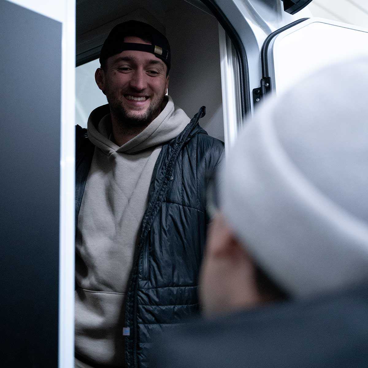 Korbinian Engstler lächelt aus einem Van heraus.