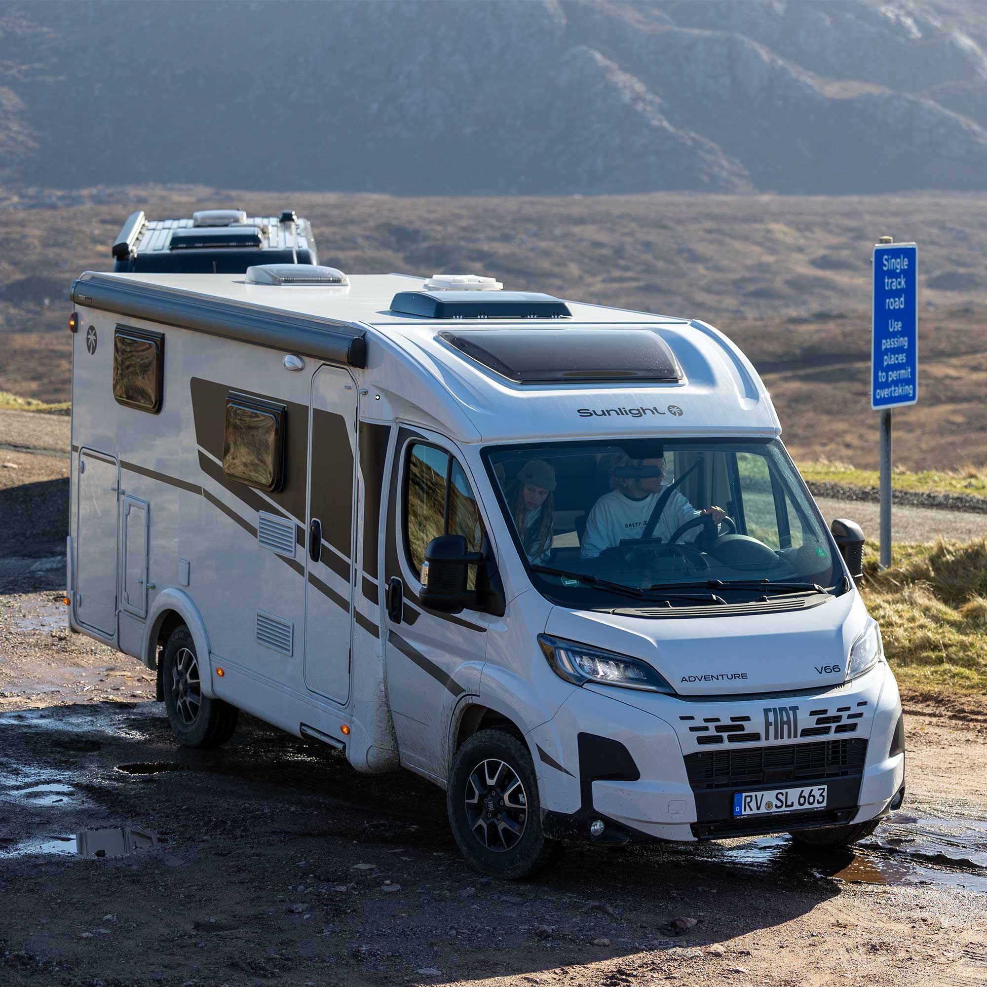 Der weiße Cliff Sunlight 4x4 Camper auf einer Straße vor einer Berglandschaft