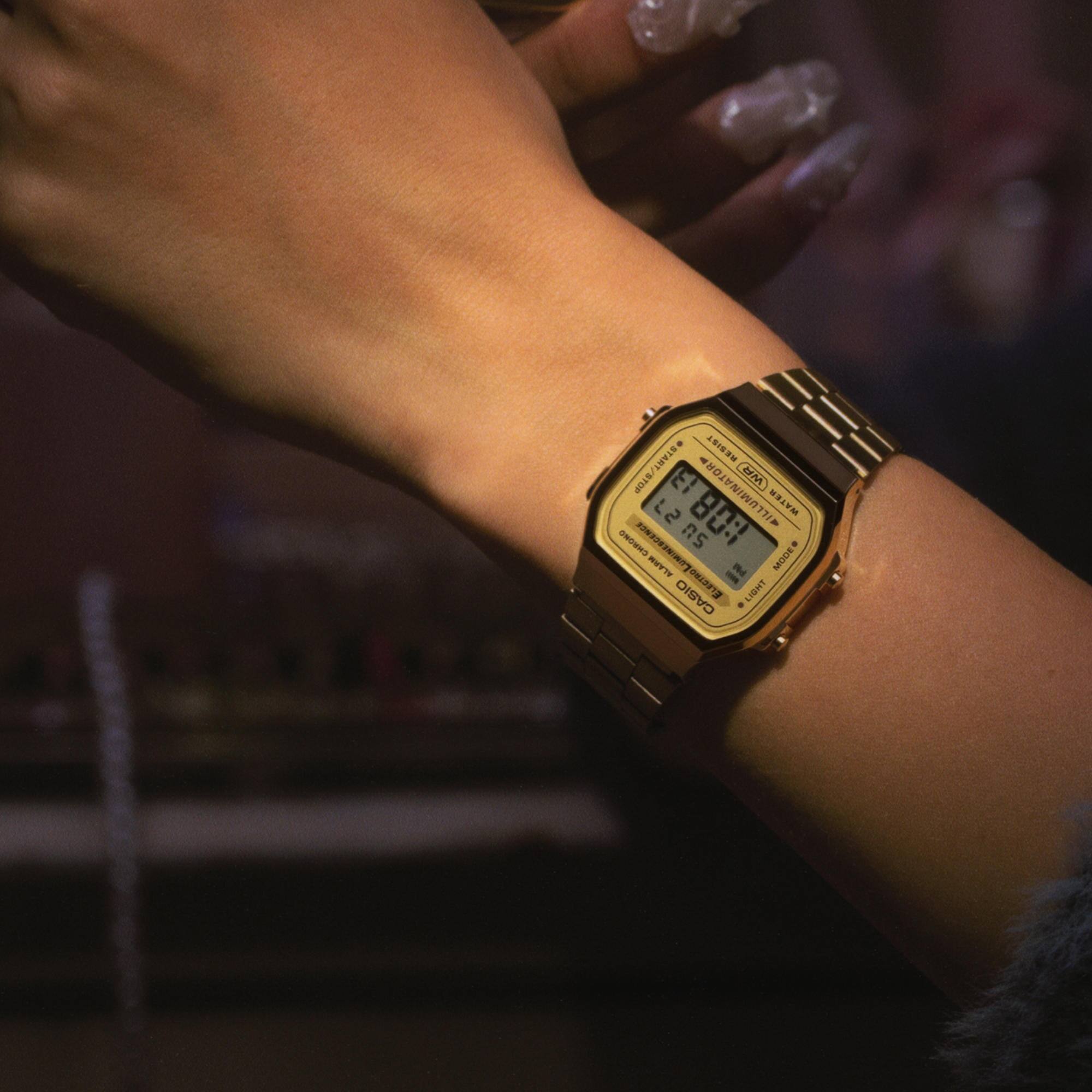 Eine Frau trägt die CASIO Vintage Armbanduhr "A168WG-9EF" mit goldfarbenem Armband und digitaler Zeitanzeige