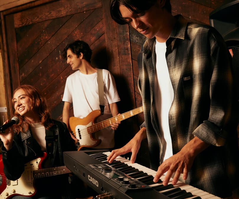 Un teclista toca el piano digital Casiotone CT-S500 junto con una cantante y un guitarrista