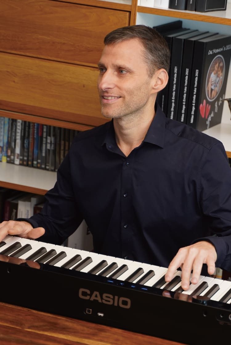 Thomas Yoshida toca su piano digital Privia negro. La imagen enlaza con tu página «Vivir con Privia».