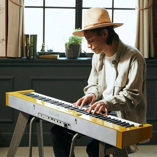 José James sentado ante su piano digital PX-S7000 amarillo de Casio tocando el piano