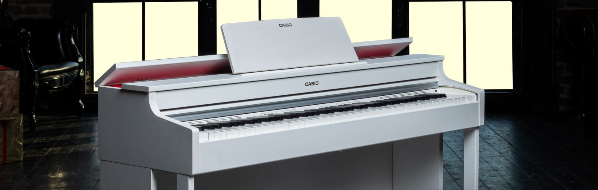 El piano digital CELVIANO blanco de CASIO en una habitación oscura 