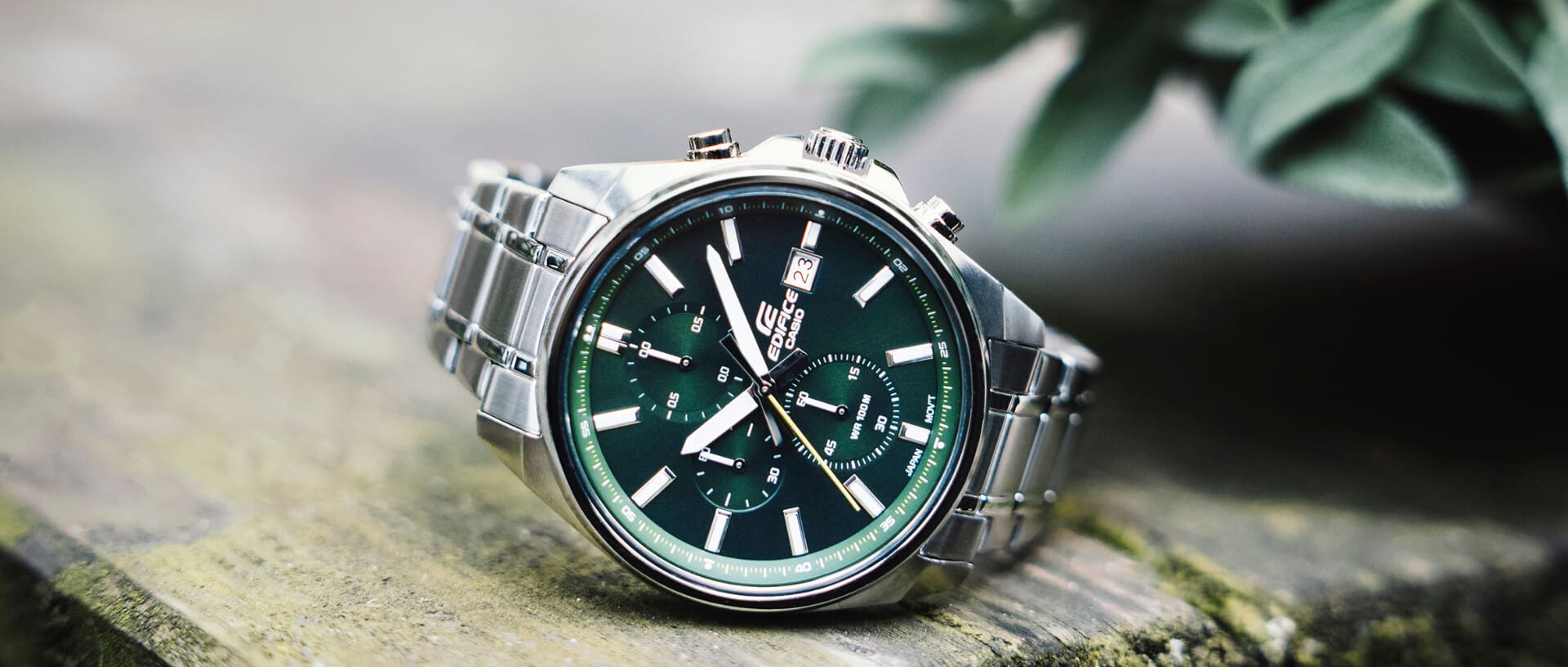 El reloj EDIFICE EFV-610D-3CV con esfera verde sobre una base de madera