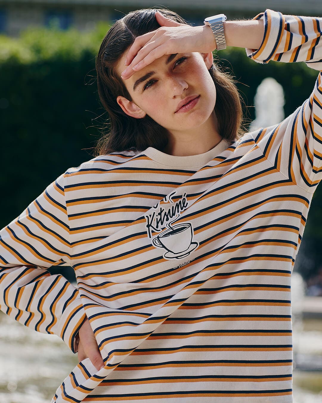 Una modelo lleva el reloj digital A168WECK de Casio Vintage y Café Kitsuné. En su jersey se puede ver el logotipo de Café Kitsuné.