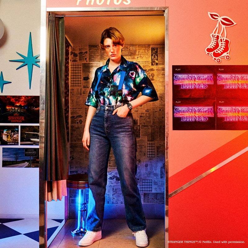Una modelo lleva el Casio vintage "A120WEST-1A". En el fondo se puede ver una escena recreada de Stranger Things.