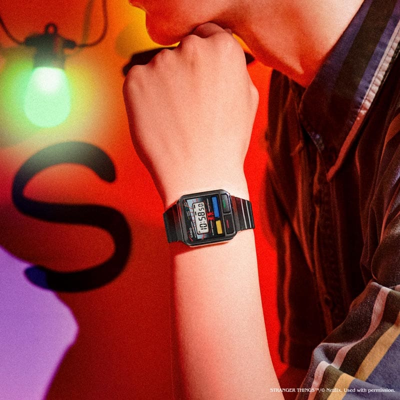 Una modelo lleva el Casio vintage "A120WEST-1A". En el fondo se puede ver una escena recreada de Stranger Things.