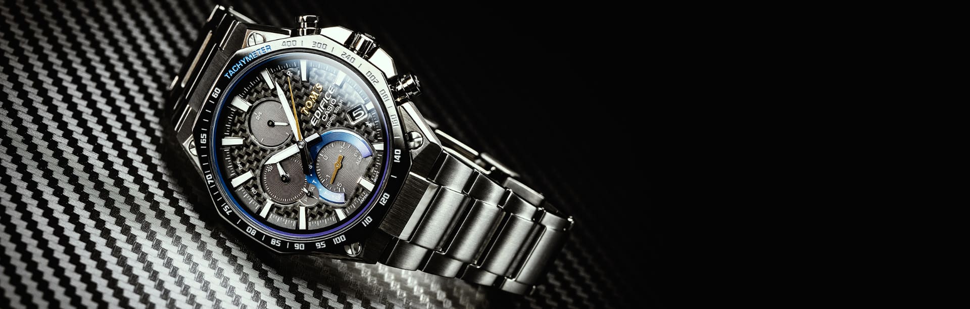 El reloj de colaboración EDIFICE x TOM's con correa plateada y esfera analógica estampada