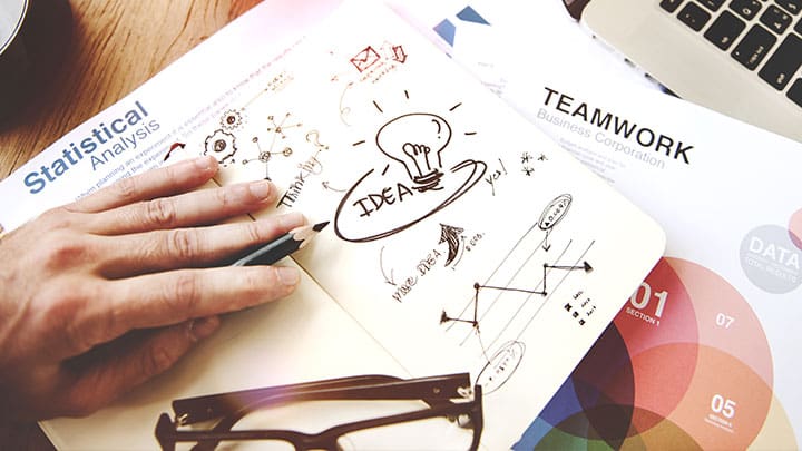 Several notepads with ideas and mind maps on top of each other