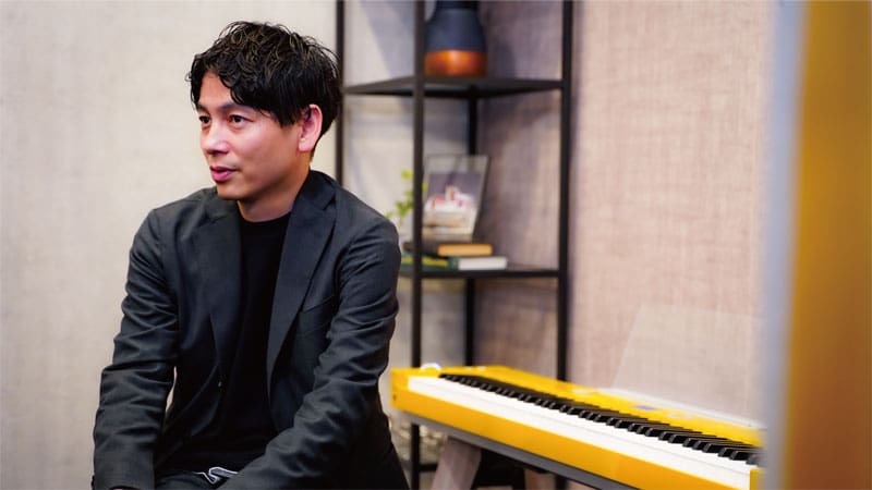 Ryota Nagasaki sits in front of his Privia in an interview.