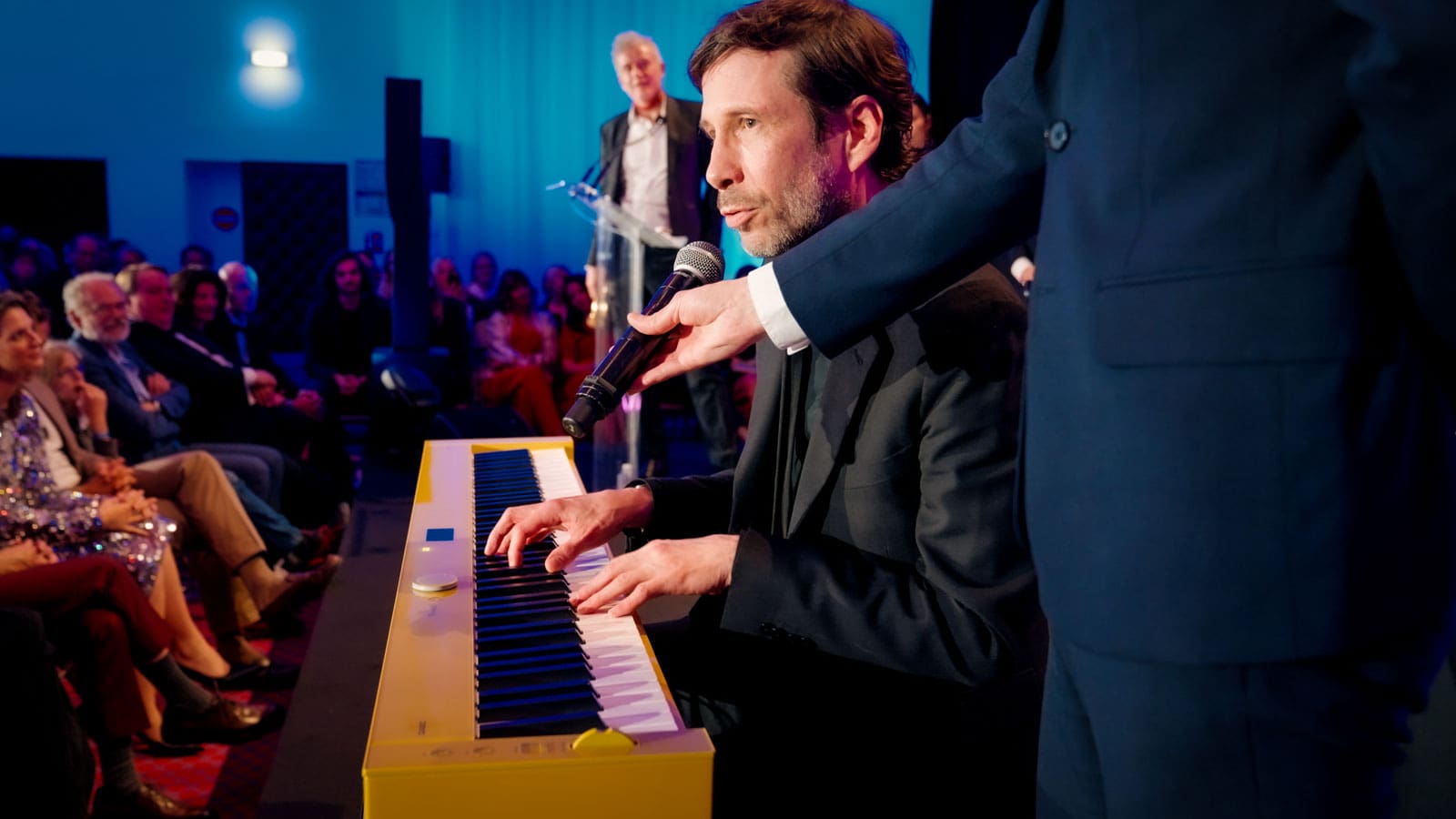 Alex Beaupain plays his Casio digital piano on stage and sings into a microphone