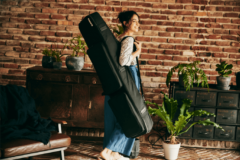 A woman carries the black SC-800 carrying case. The image links to the product page.